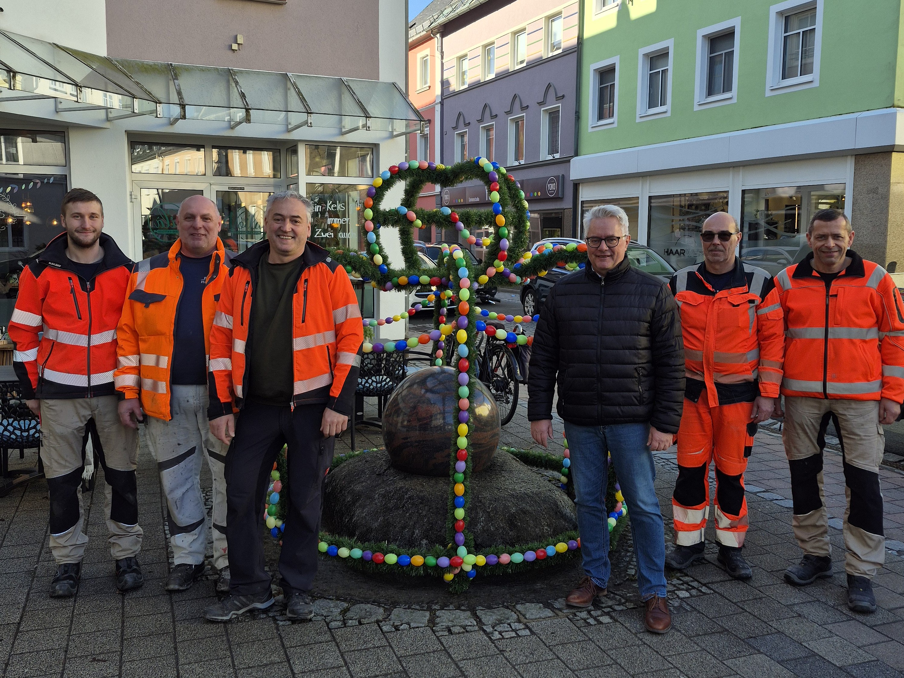 Osterkrone am Kugelbrunnen Bunte Osterkrone am Kugelbrunnen in der Helmbrechtser Innenstadt mit Baubetriebshofmitarbeitern und dem Bürgermeister
